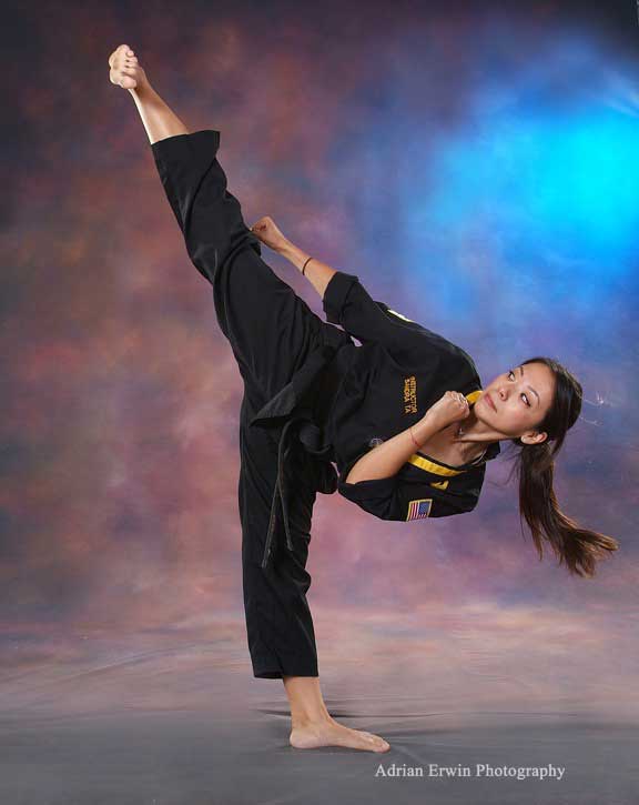 Taekwondo girl spinning jump kicks high